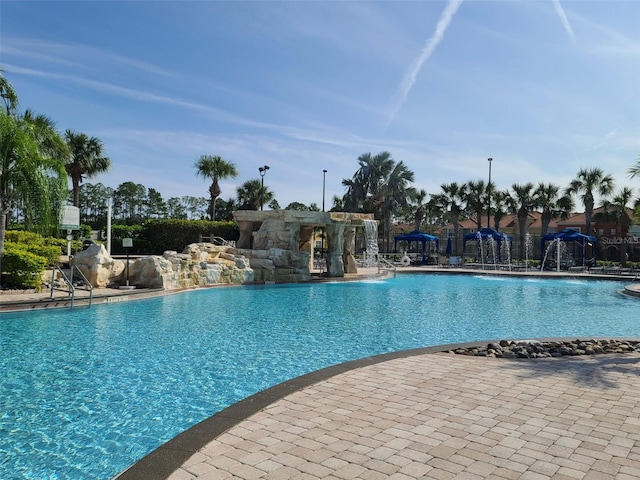 view of swimming pool with pool water feature and a patio area