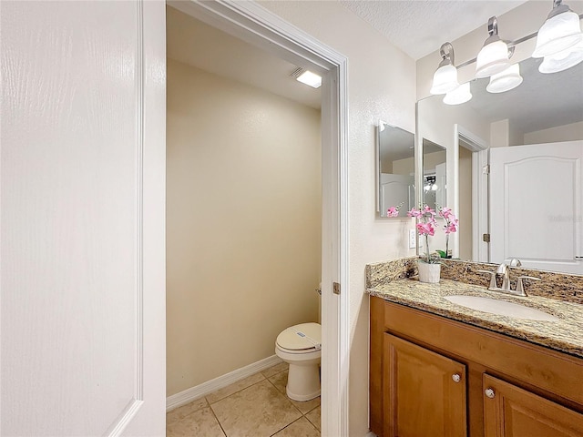 bathroom featuring tile patterned flooring, vanity, and toilet