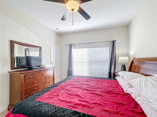 bedroom with carpet flooring, ceiling fan, and a textured ceiling