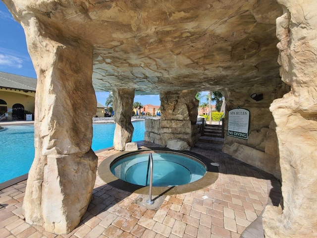 view of swimming pool featuring a hot tub