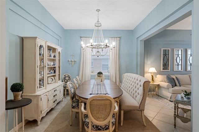 dining room with light tile patterned floors and an inviting chandelier