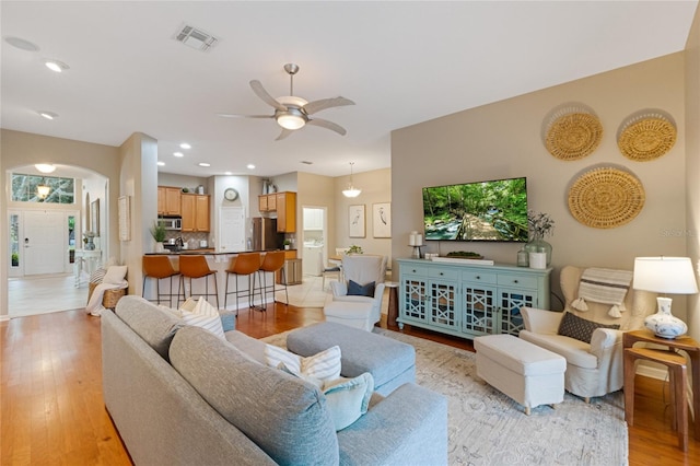 living room featuring ceiling fan and light hardwood / wood-style flooring