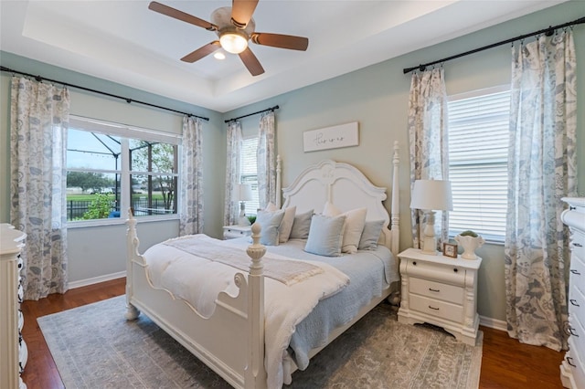 bedroom featuring multiple windows, ceiling fan, and dark wood-type flooring