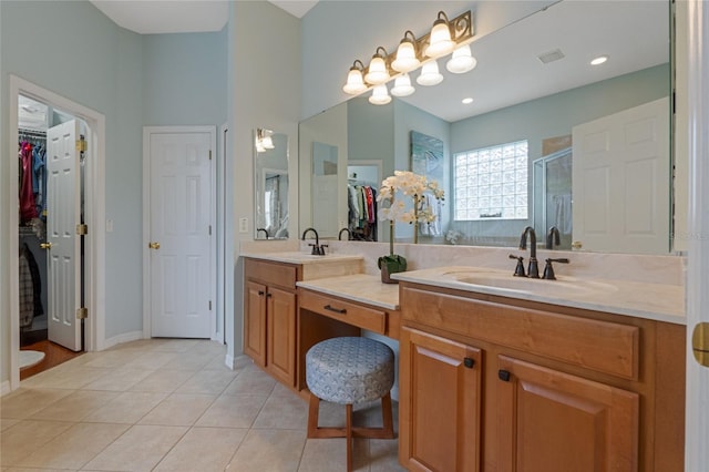 bathroom featuring tile patterned floors, vanity, and a shower with door