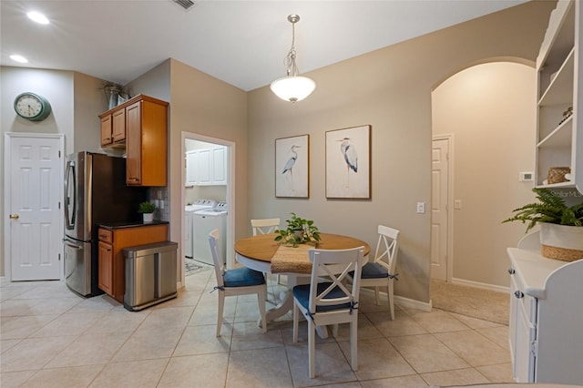 dining room with light tile patterned flooring and independent washer and dryer