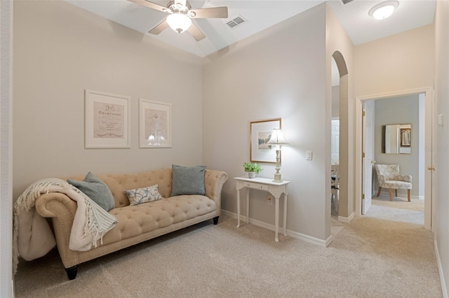 living area with ceiling fan and light colored carpet