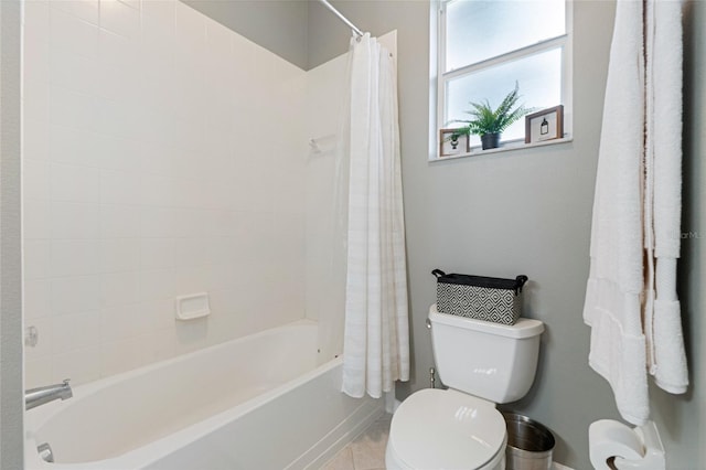 bathroom featuring tile patterned flooring, shower / bath combination with curtain, and toilet