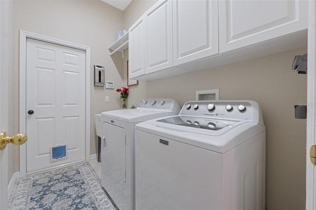 laundry room with washer and clothes dryer and cabinets