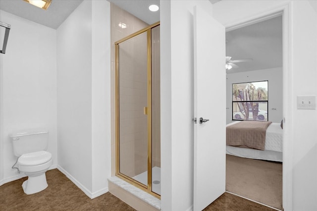 bathroom with toilet, a shower with door, and ceiling fan