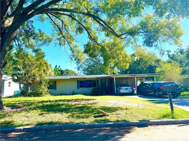 ranch-style home featuring a front lawn and a carport