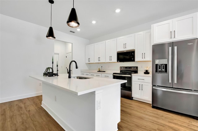 kitchen with a kitchen island with sink, white cabinets, hanging light fixtures, sink, and appliances with stainless steel finishes