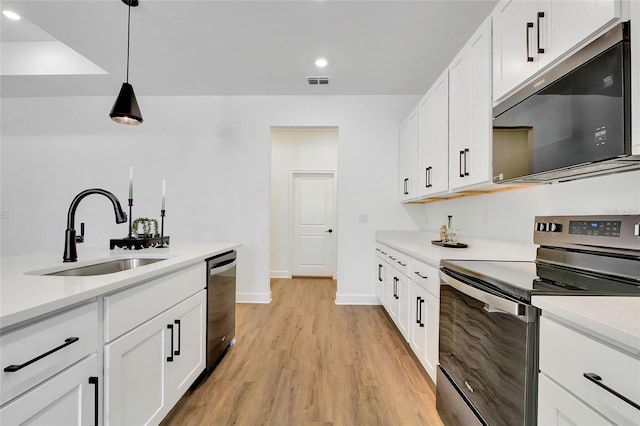 kitchen featuring white cabinetry, sink, pendant lighting, appliances with stainless steel finishes, and light wood-type flooring