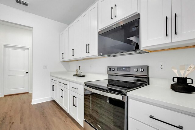 kitchen featuring light wood-type flooring, white cabinetry, and stainless steel range with electric stovetop