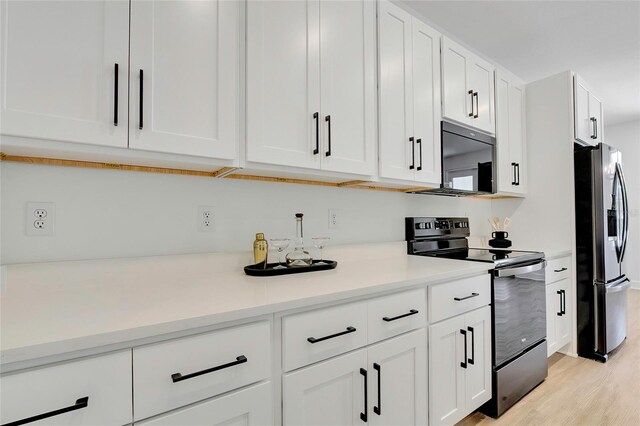 kitchen with white cabinets, light hardwood / wood-style floors, and black appliances