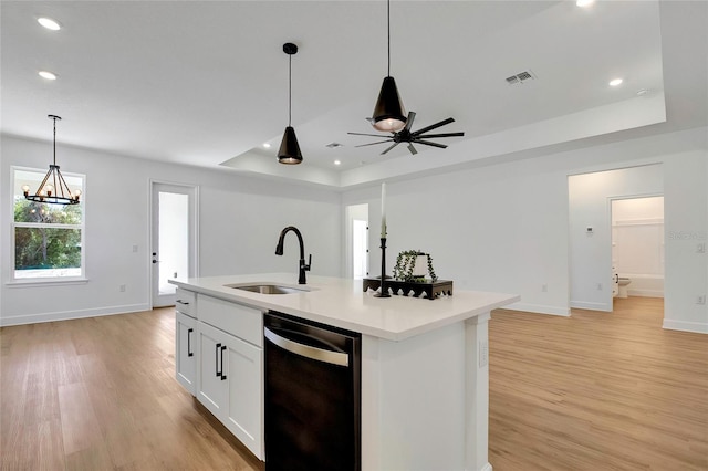 kitchen with light wood-type flooring, stainless steel dishwasher, sink, white cabinets, and an island with sink