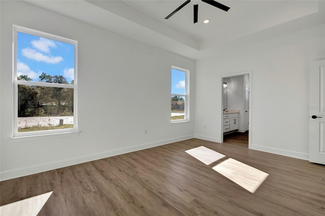 unfurnished bedroom with ensuite bath, ceiling fan, and dark hardwood / wood-style floors