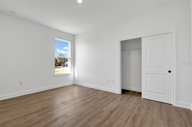 unfurnished bedroom with hardwood / wood-style floors and a closet