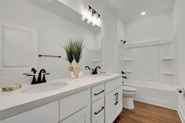 full bathroom with vanity, wood-type flooring, shower / bathtub combination, and toilet