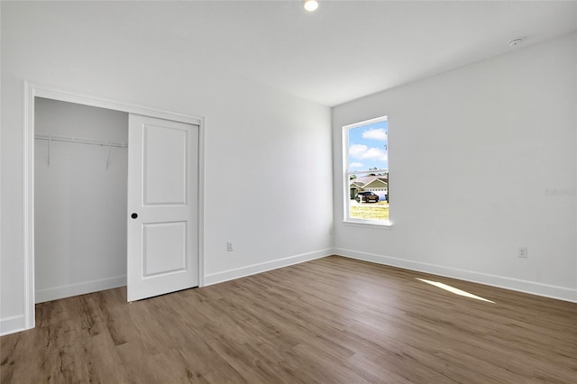 unfurnished bedroom with wood-type flooring and a closet