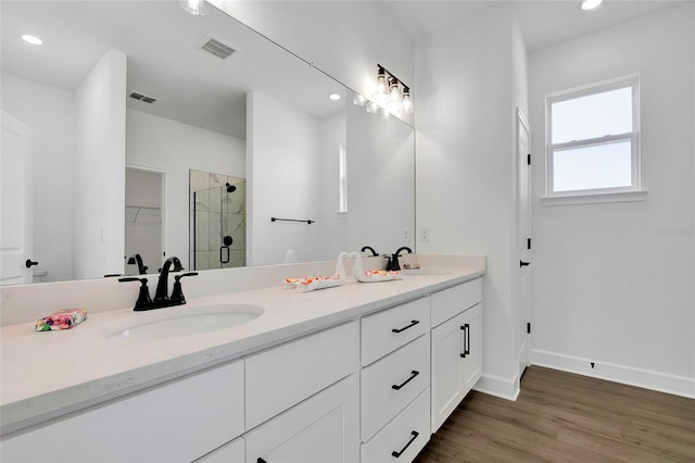 bathroom with vanity, wood-type flooring, and a shower with shower door