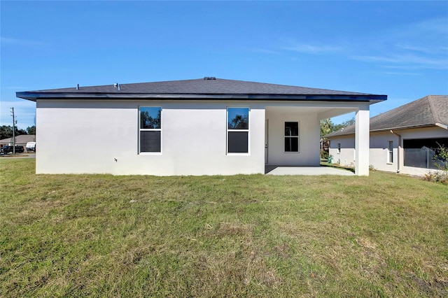 rear view of property with a lawn and a patio