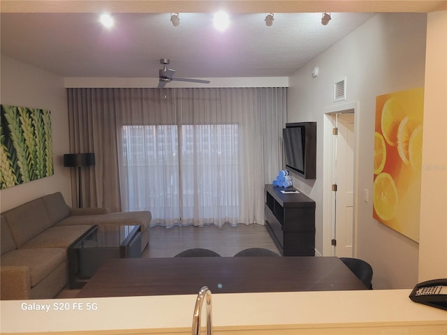 living room with ceiling fan and a textured ceiling