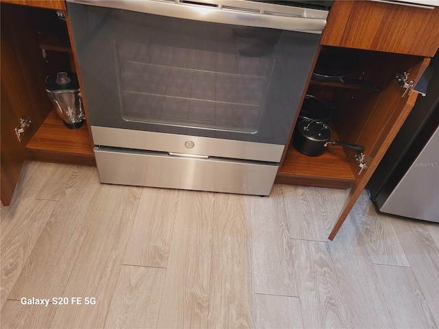 details featuring light hardwood / wood-style floors and stainless steel range oven