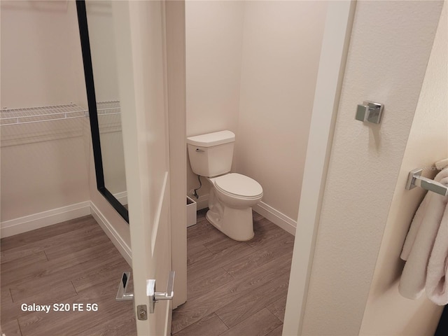 bathroom with hardwood / wood-style flooring and toilet