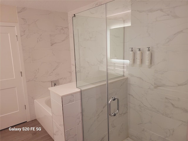 bathroom featuring hardwood / wood-style flooring and separate shower and tub