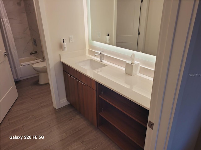 full bathroom featuring shower / bath combination with curtain, vanity, wood-type flooring, and toilet