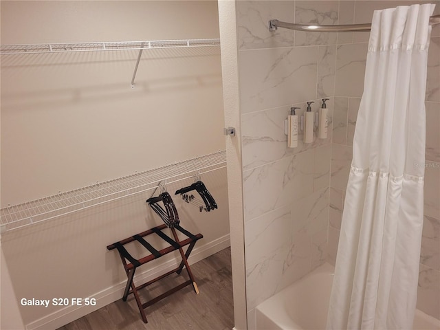 bathroom featuring wood-type flooring and shower / tub combo with curtain