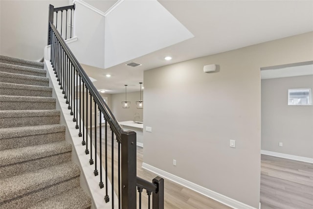 stairs with hardwood / wood-style floors and sink