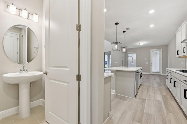 bathroom with dual sinks and wood-type flooring