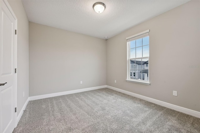 carpeted empty room featuring a textured ceiling