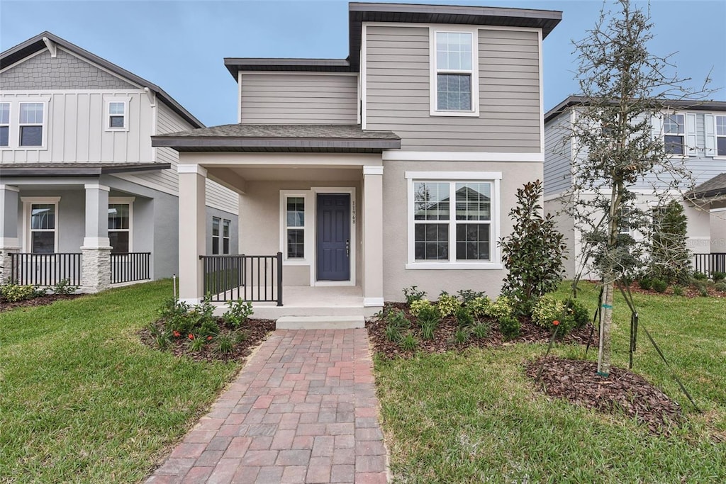 view of front of home with covered porch and a front lawn