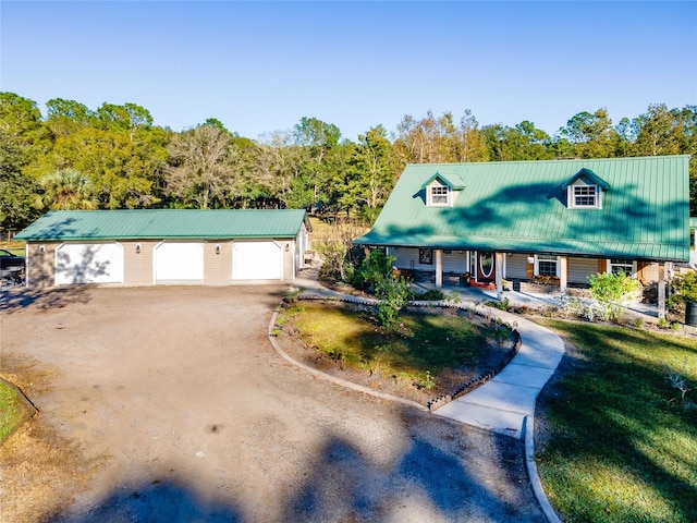 view of front of property featuring an outbuilding, covered porch, and a garage