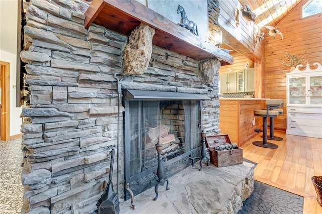 room details featuring a fireplace, hardwood / wood-style flooring, and wooden walls