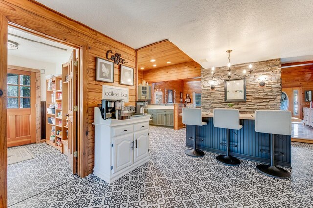 kitchen featuring pendant lighting, a kitchen bar, kitchen peninsula, and a textured ceiling