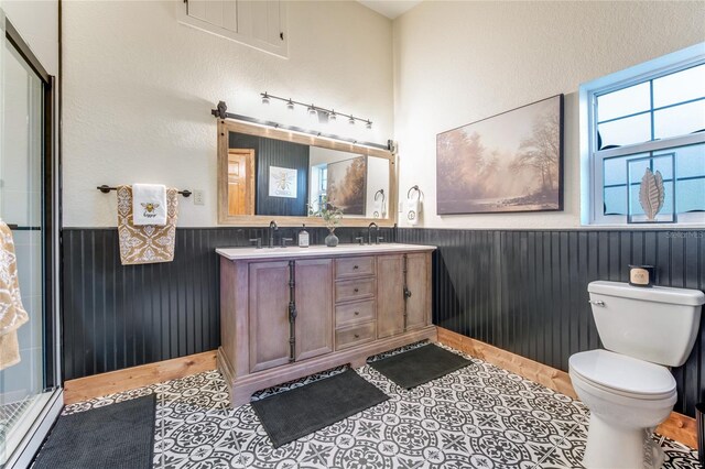 bathroom featuring tile patterned flooring, vanity, toilet, and an enclosed shower