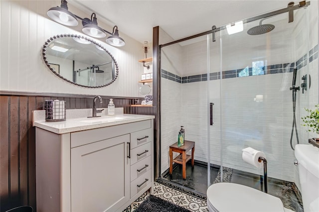 bathroom with wooden walls, vanity, a shower with shower door, and toilet