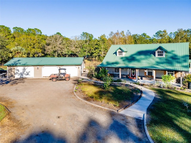 view of front of house with a garage, covered porch, and an outbuilding