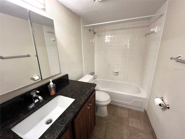 full bathroom with tile patterned floors, toilet, a textured ceiling, vanity, and tiled shower / bath combo