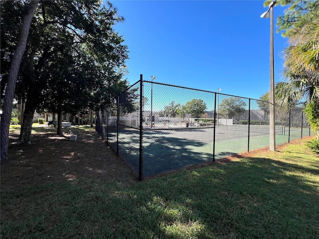 view of tennis court featuring a lawn