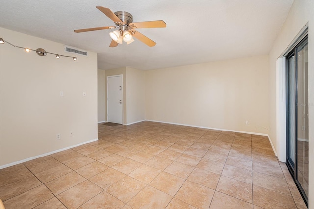 tiled spare room with ceiling fan and a textured ceiling