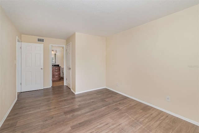 spare room with hardwood / wood-style floors and a textured ceiling