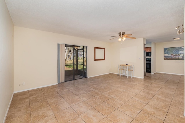 unfurnished living room with ceiling fan, a textured ceiling, and light tile patterned floors