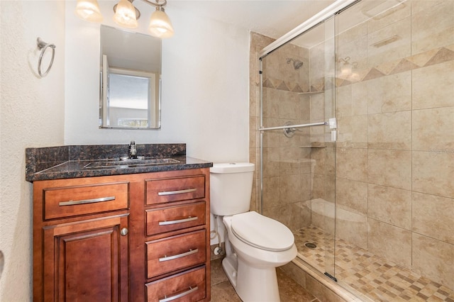 bathroom with vanity, toilet, and a shower with door