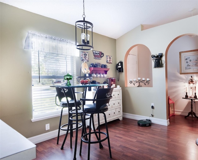 dining room with lofted ceiling, a chandelier, and dark hardwood / wood-style floors