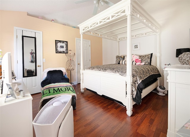 bedroom with ceiling fan, dark wood-type flooring, and vaulted ceiling