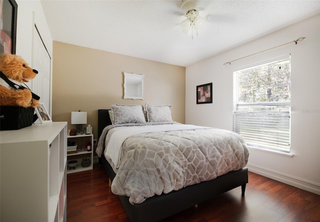 bedroom featuring a closet, dark hardwood / wood-style floors, and ceiling fan